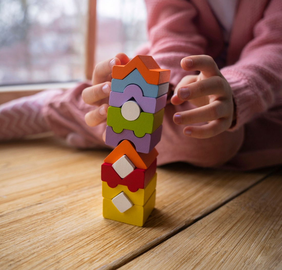 kislány épít színes játékokból